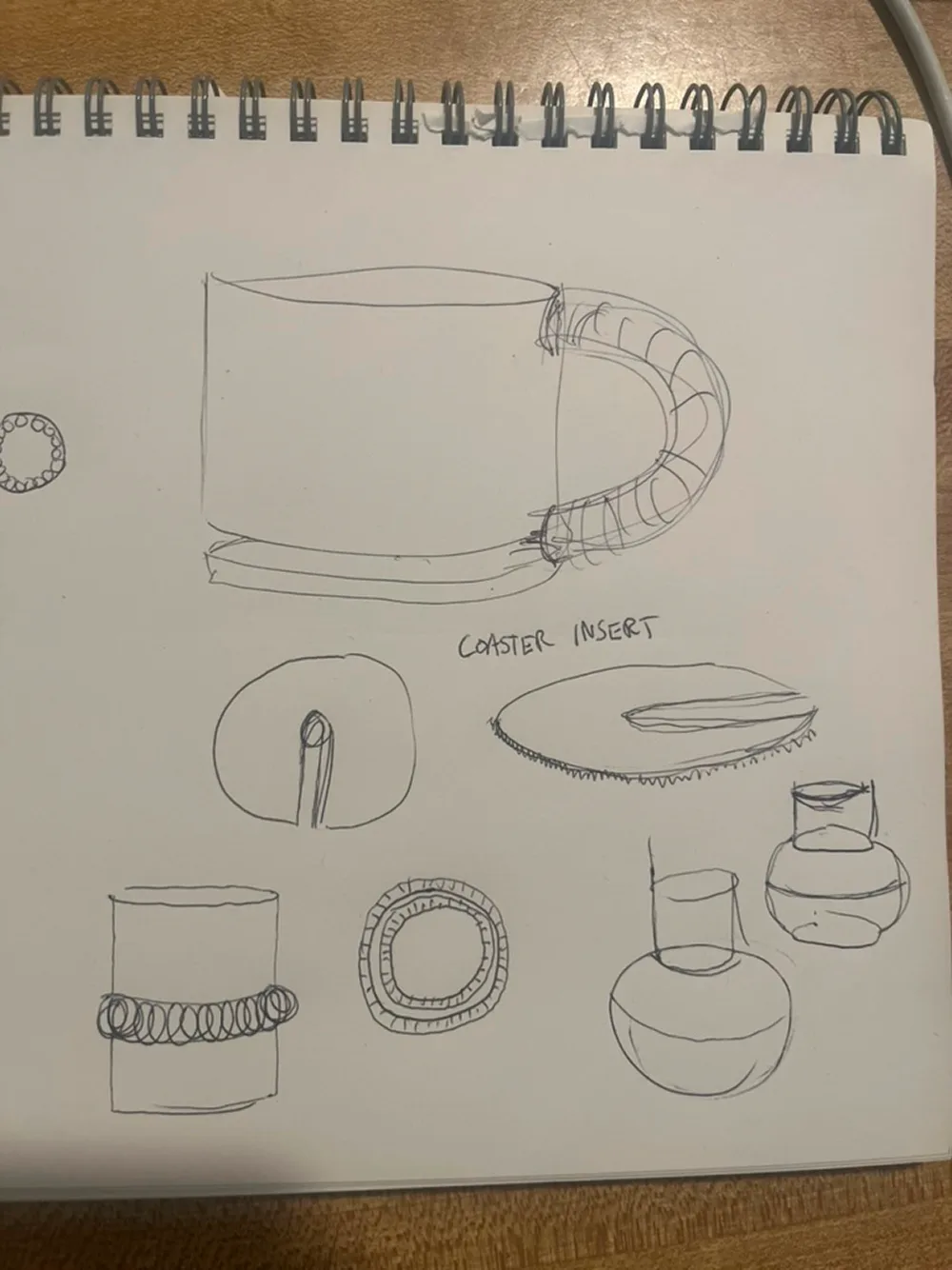Sketchbook page of mug ideas, including a removable coaster insert