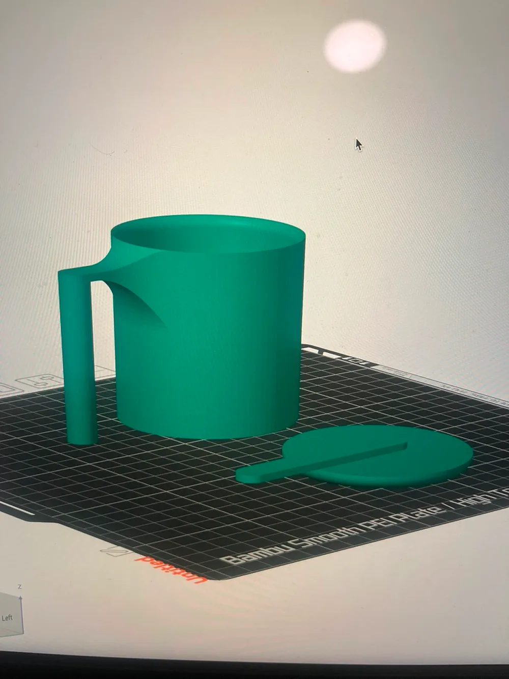 Green mug printing on a 3D printer bed